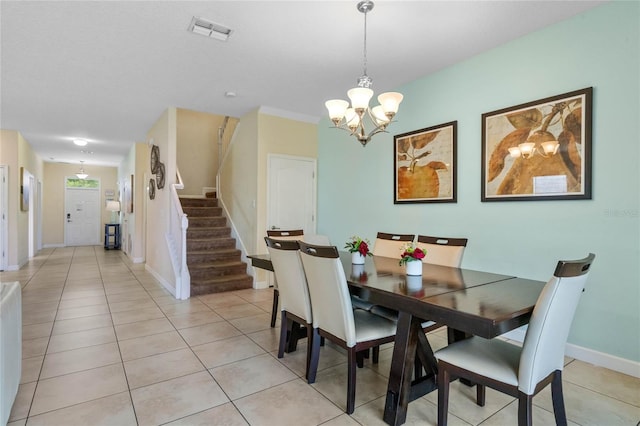 tiled dining room featuring an inviting chandelier