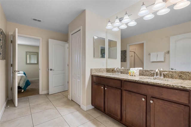 bathroom with a shower with shower door, tile patterned floors, and vanity