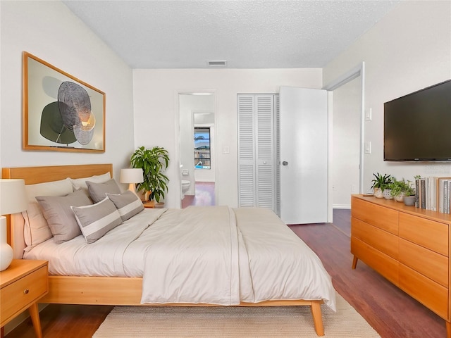 bedroom with dark hardwood / wood-style flooring and a textured ceiling