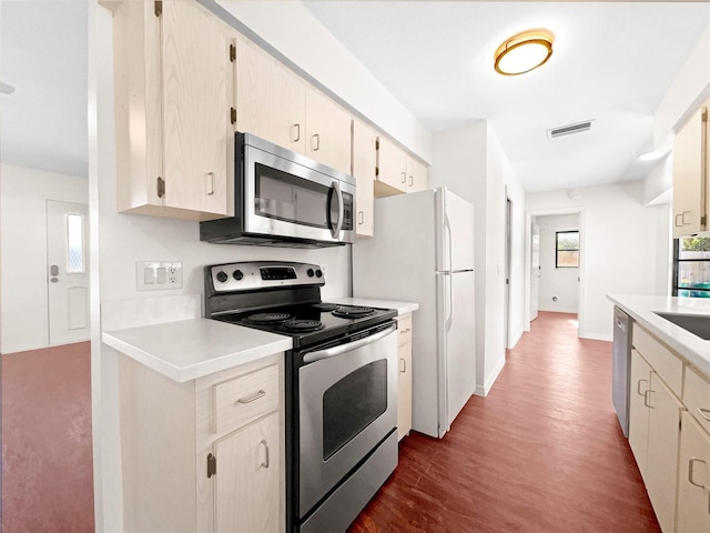 kitchen featuring cream cabinetry, dark hardwood / wood-style flooring, sink, and appliances with stainless steel finishes