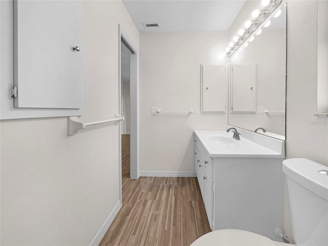 bathroom featuring hardwood / wood-style floors, vanity, and toilet