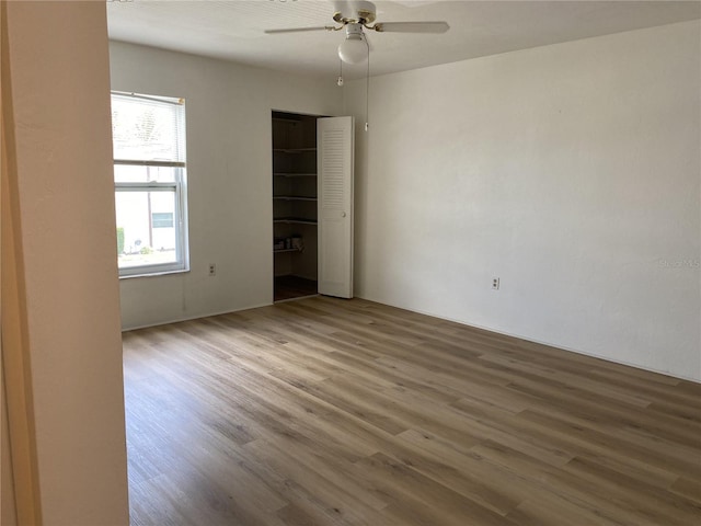 unfurnished room featuring a wealth of natural light, ceiling fan, and hardwood / wood-style flooring