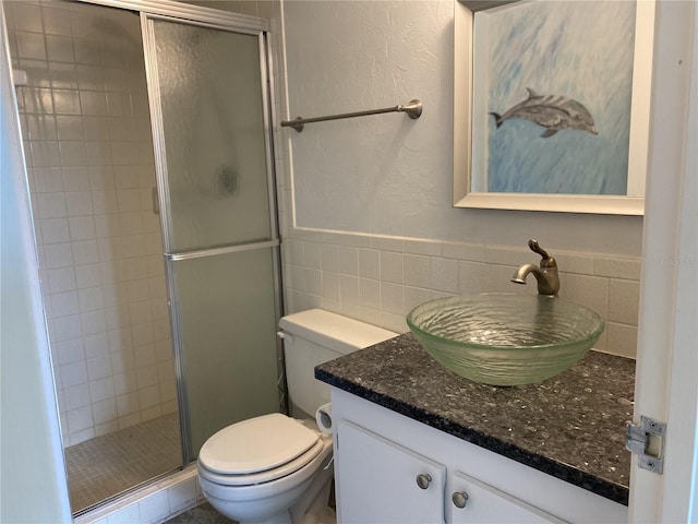 bathroom featuring vanity, toilet, and a shower with door