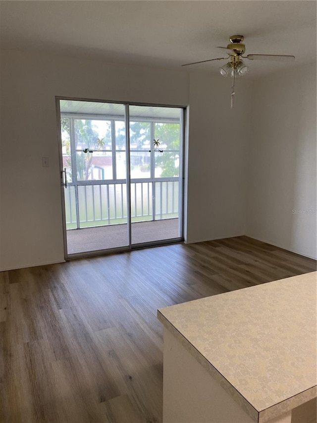 unfurnished room with hardwood / wood-style floors, ceiling fan, and a wealth of natural light