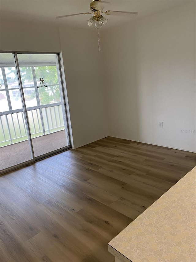 empty room featuring ceiling fan and dark hardwood / wood-style flooring