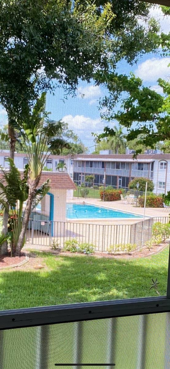 view of swimming pool with a yard