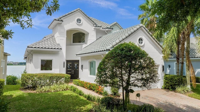 mediterranean / spanish home with a front yard and french doors