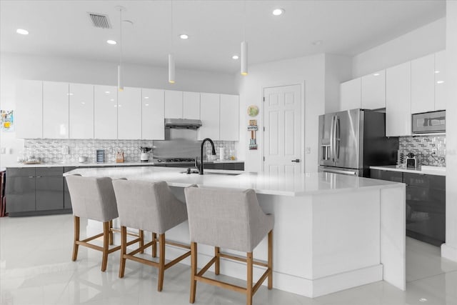 kitchen with a center island with sink, white cabinetry, stainless steel fridge with ice dispenser, and hanging light fixtures