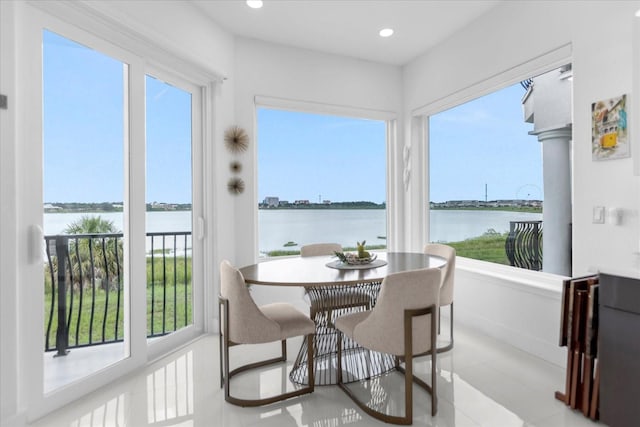 sunroom featuring a water view