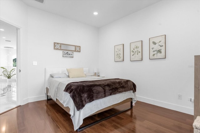 bedroom with access to exterior and hardwood / wood-style floors