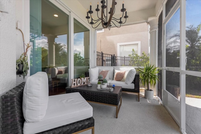 sunroom / solarium featuring a notable chandelier