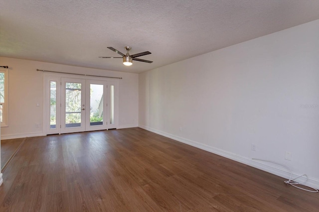 spare room featuring ceiling fan, a textured ceiling, dark hardwood / wood-style flooring, and french doors