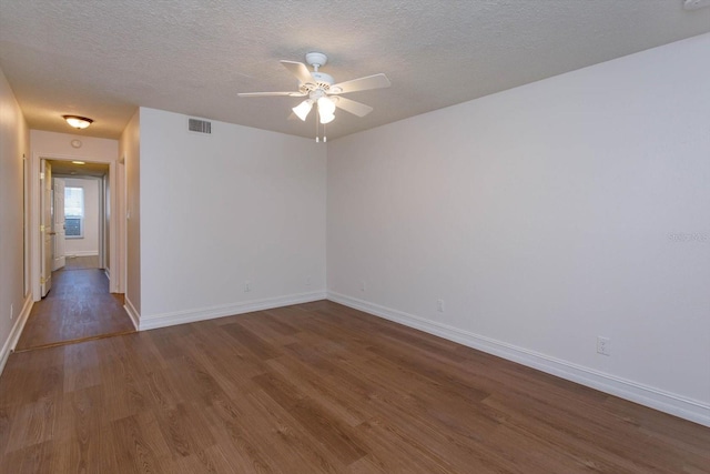 empty room featuring ceiling fan, a textured ceiling, and dark hardwood / wood-style flooring