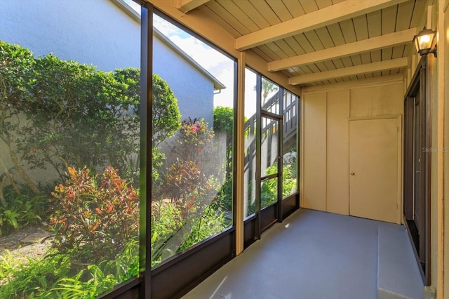 unfurnished sunroom with a wealth of natural light and beamed ceiling