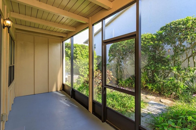 unfurnished sunroom featuring beam ceiling