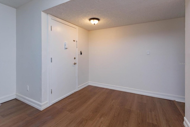 spare room with hardwood / wood-style floors and a textured ceiling