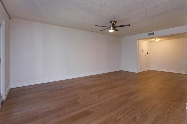 empty room with hardwood / wood-style flooring, ceiling fan, and a textured ceiling