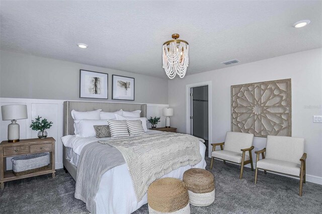 carpeted bedroom with a textured ceiling and an inviting chandelier