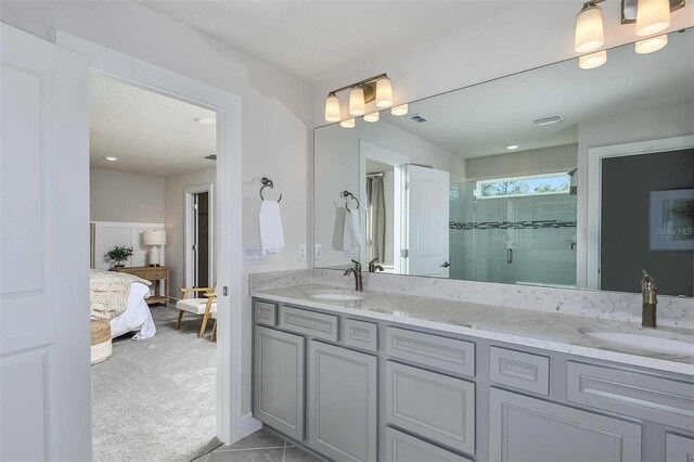 bathroom featuring tile patterned flooring, vanity, and a shower with shower door