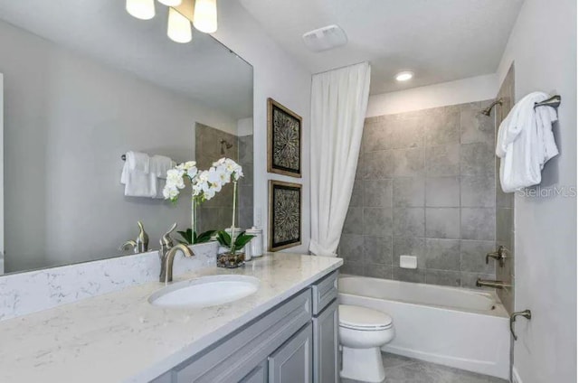 full bathroom with tile patterned flooring, shower / bath combination with curtain, vanity, and toilet