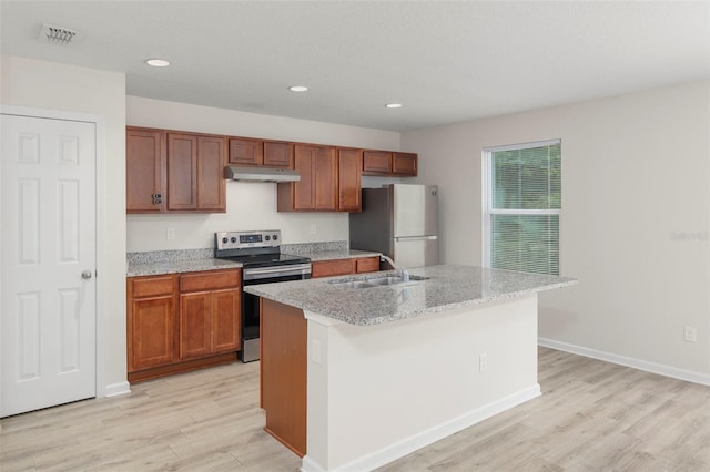 kitchen featuring sink, an island with sink, appliances with stainless steel finishes, and light hardwood / wood-style flooring