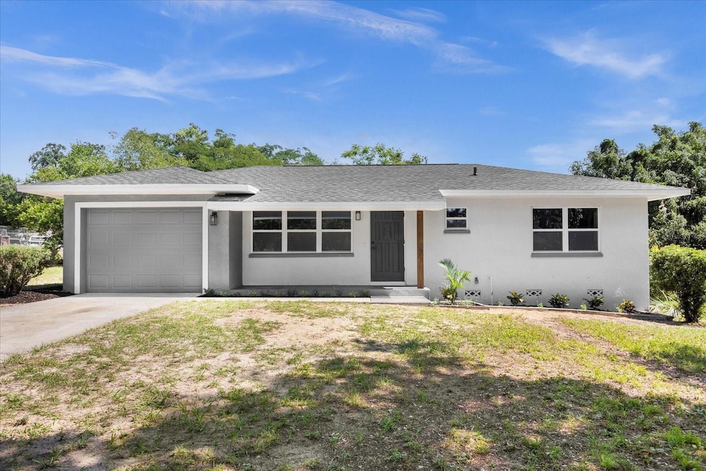 single story home featuring a garage and a front lawn