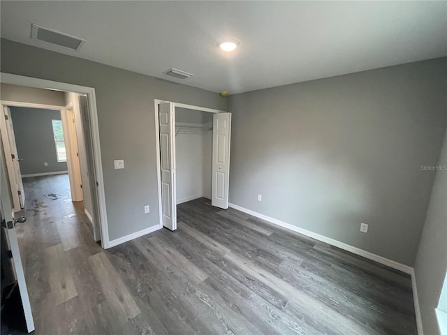 unfurnished bedroom featuring dark wood-type flooring and a closet