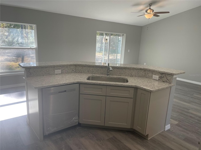 kitchen featuring a healthy amount of sunlight, dishwasher, sink, and light stone countertops