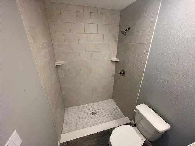 bathroom with tiled shower and toilet