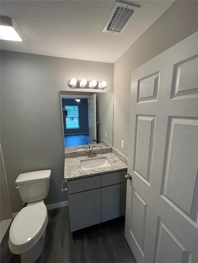 bathroom with vanity, hardwood / wood-style floors, and toilet