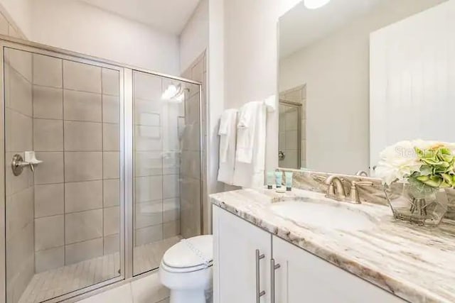 bathroom with vanity, walk in shower, and toilet