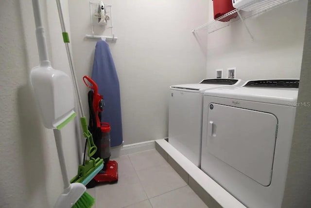 washroom featuring washing machine and dryer and light tile patterned floors