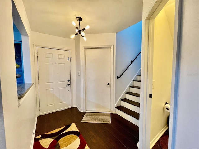 entryway with dark hardwood / wood-style floors and an inviting chandelier