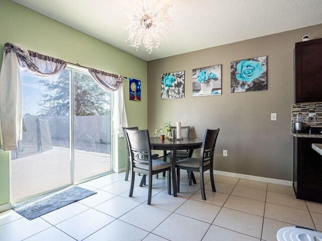 dining area with a chandelier and light tile floors