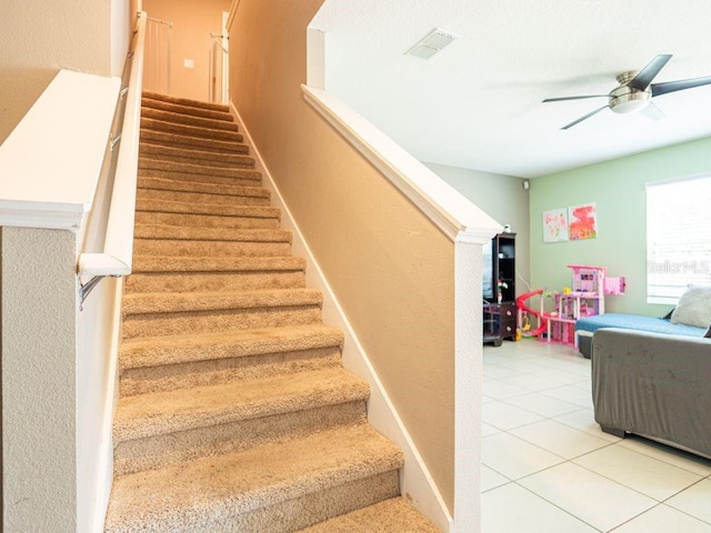 stairs with ceiling fan and light tile flooring