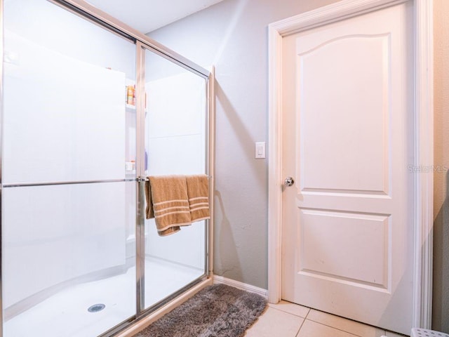 bathroom featuring tile floors and a shower with shower door