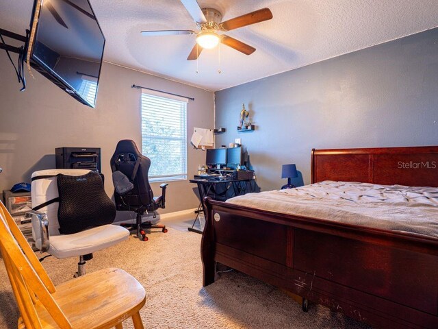 bedroom featuring carpet flooring, ceiling fan, and a textured ceiling