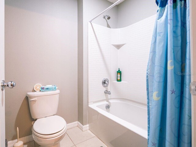 bathroom featuring tile flooring, shower / tub combo, and toilet