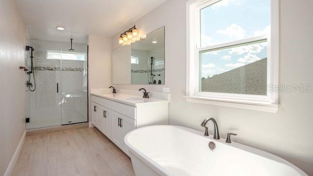 bathroom with vanity, independent shower and bath, hardwood / wood-style flooring, and a wealth of natural light