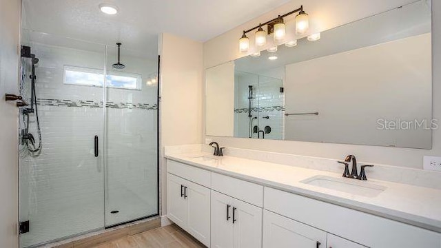 bathroom with double sink vanity and an enclosed shower