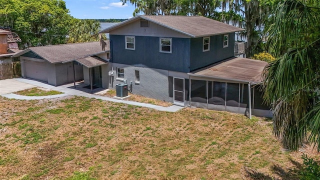 back of house with a sunroom, central air condition unit, and a lawn