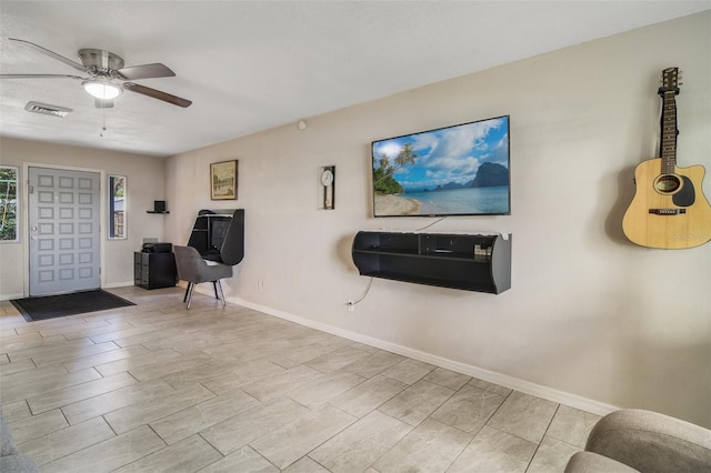 sitting room featuring ceiling fan and light tile floors