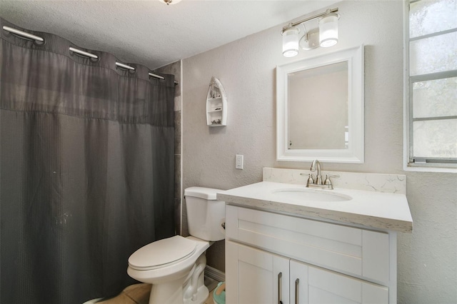 bathroom with a textured ceiling, oversized vanity, and toilet