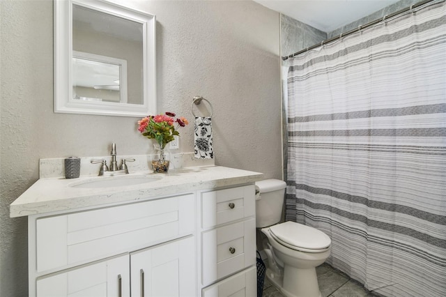 bathroom featuring tile floors, vanity with extensive cabinet space, and toilet