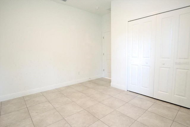 unfurnished bedroom featuring light tile patterned flooring and a closet