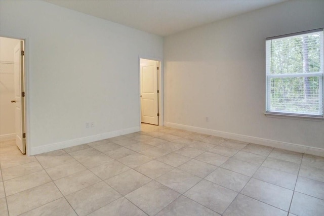 unfurnished room featuring light tile patterned floors and baseboards