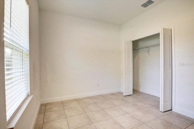 unfurnished bedroom with light tile patterned floors, visible vents, and baseboards