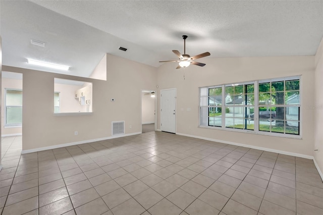 unfurnished room featuring lofted ceiling, a textured ceiling, ceiling fan, and light tile patterned flooring