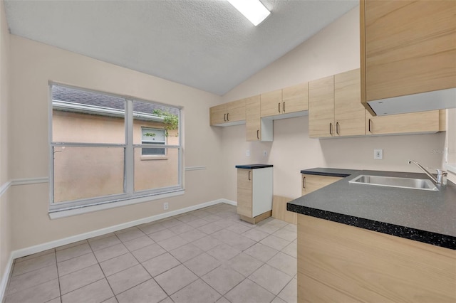 2519 Woods Edge Cir, Orlando, FL 32817 - kitchen featuring a sink, a textured ceiling, light brown cabinetry, light tile patterned floors, and lofted ceiling