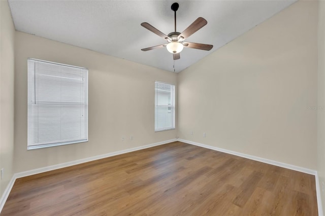 unfurnished room with hardwood / wood-style flooring, vaulted ceiling, and ceiling fan